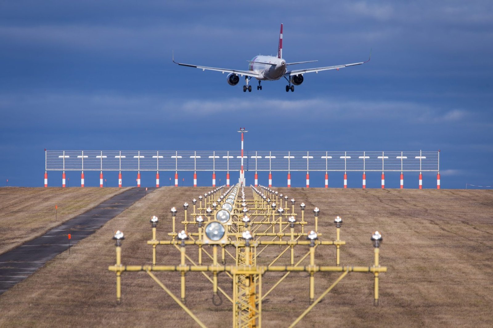 Aircraft landing with runway lights at dusk